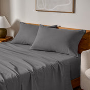 Cotton flannel sheets and pillows on a wooden bed in a bedroom setting.