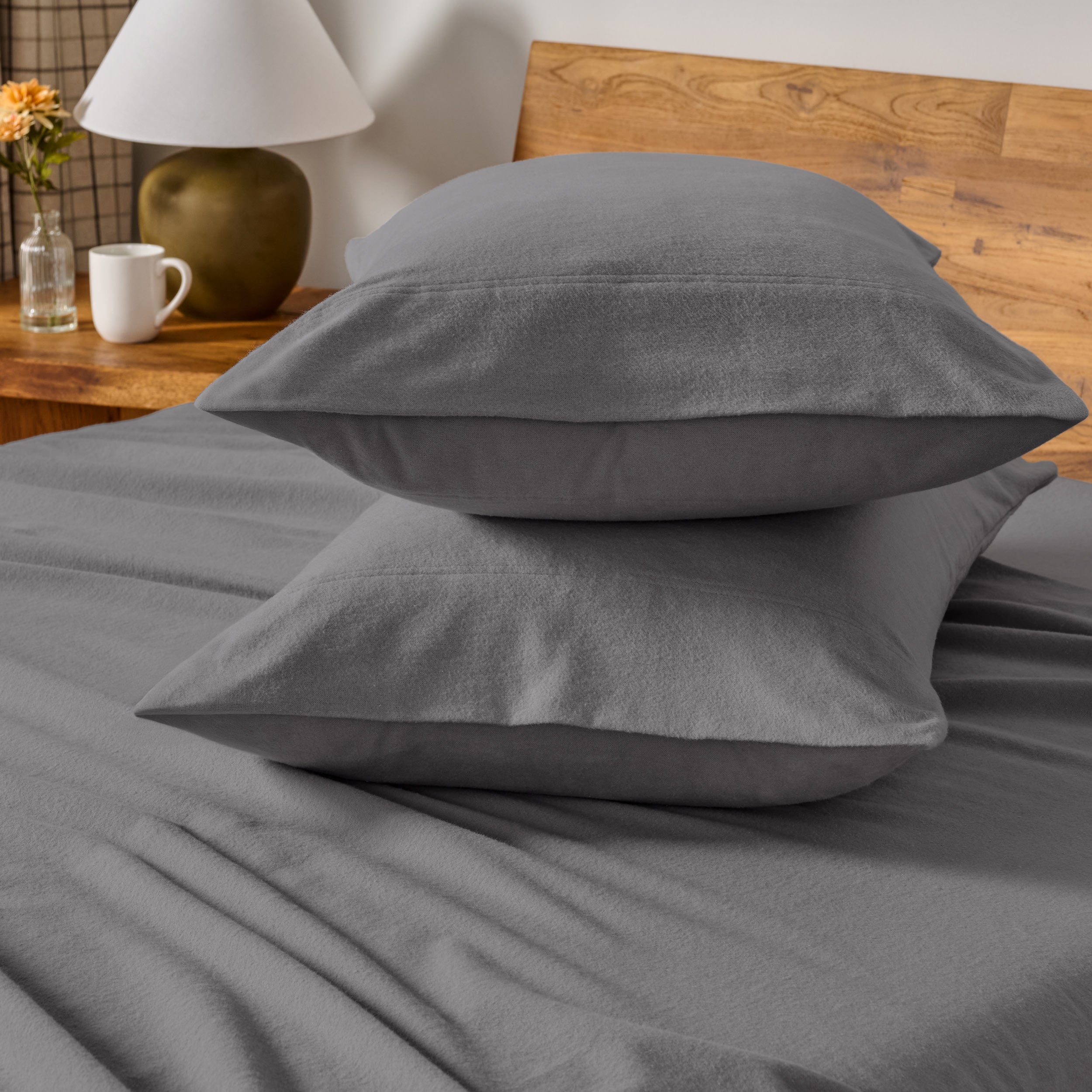 Flannel bedding set on a bed with a beige headboard and lamp.