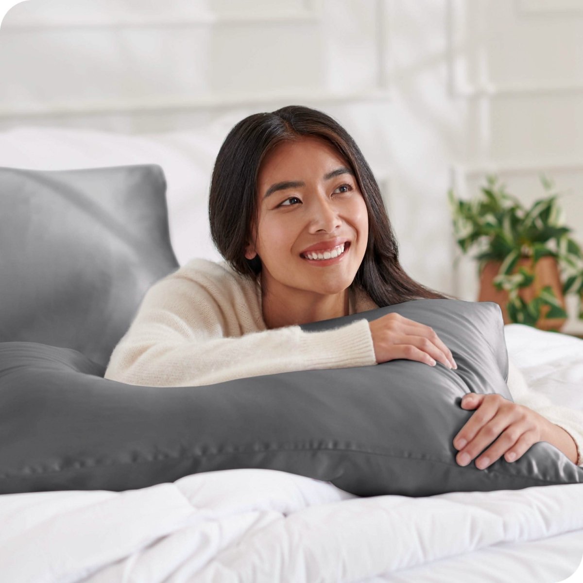 A woman lying on a bed with silk pillowcases