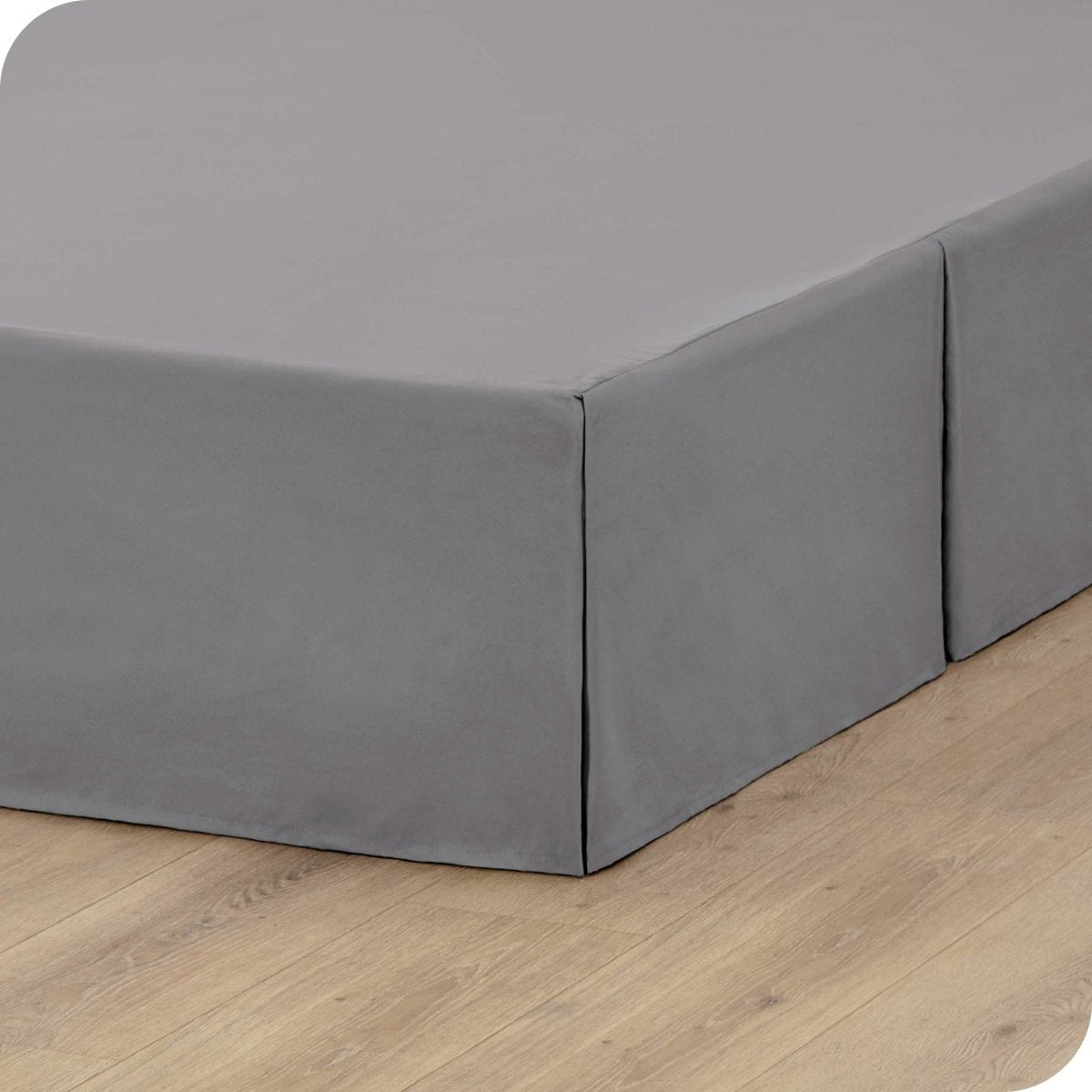 A box spring with a bed skirt on it