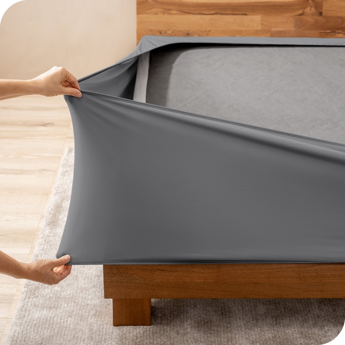 A person stretching a box spring cover