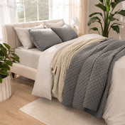 Side view of bed with coverlet set draped on a bed made with a duvet set
