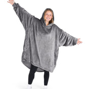 A woman wearing a hooded blanket made of microplush, showcasing comfort and warmth