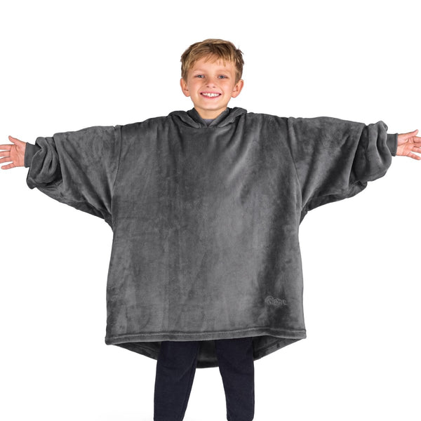 A boy wearing a blanket made of microplush, showcasing comfort and warmth.