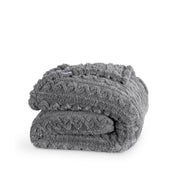 A cable knit sherpa blanket folded neatly
