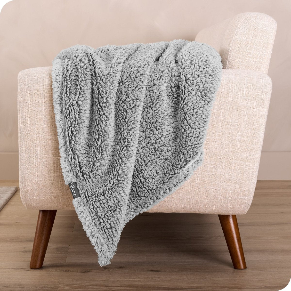 A sherpa blanket is hanging over the edge of a chair
