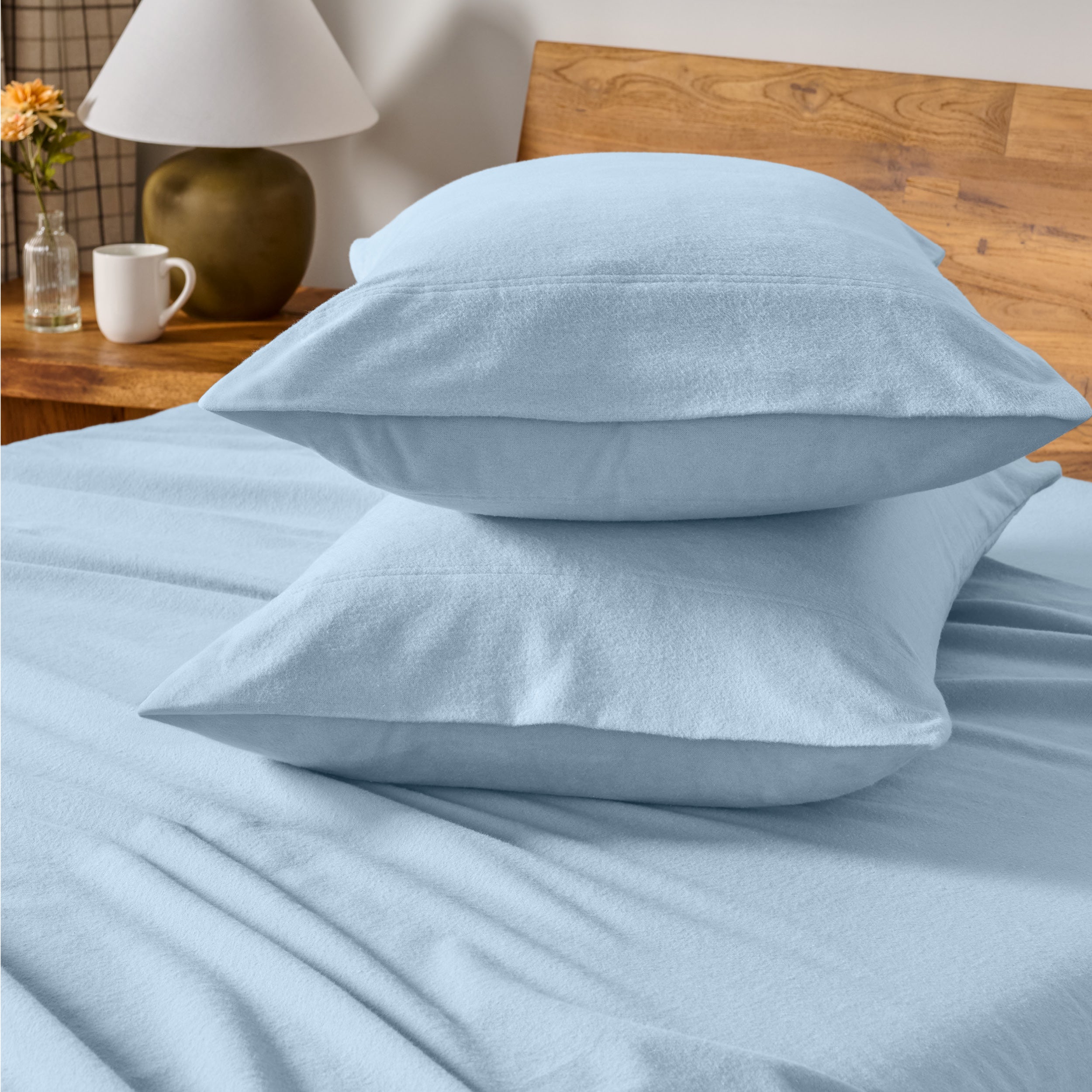 Flannel bedding set on a bed with a beige headboard and lamp.