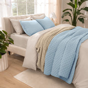 Side view of bed with coverlet set draped on a bed made with a duvet set