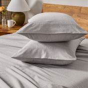 Flannel bedding set on a bed with a beige headboard and lamp.