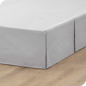 A box spring with a bed skirt on it