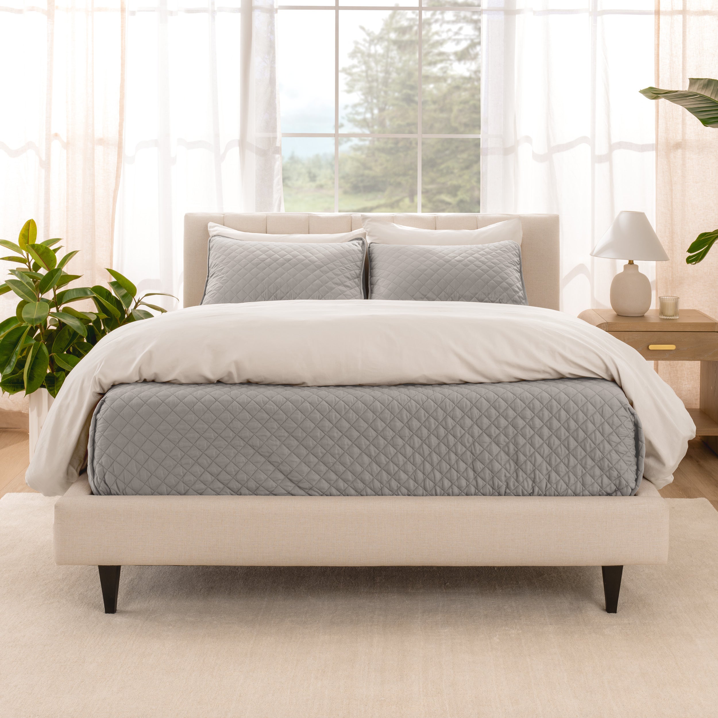 A bright bedroom with a coverlet set on the bed