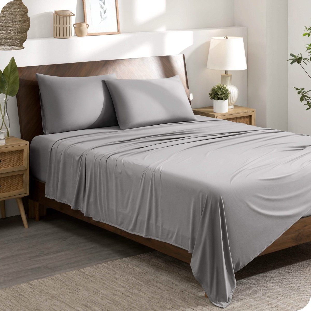 A modern bedroom set with a grey sheet set on the bed