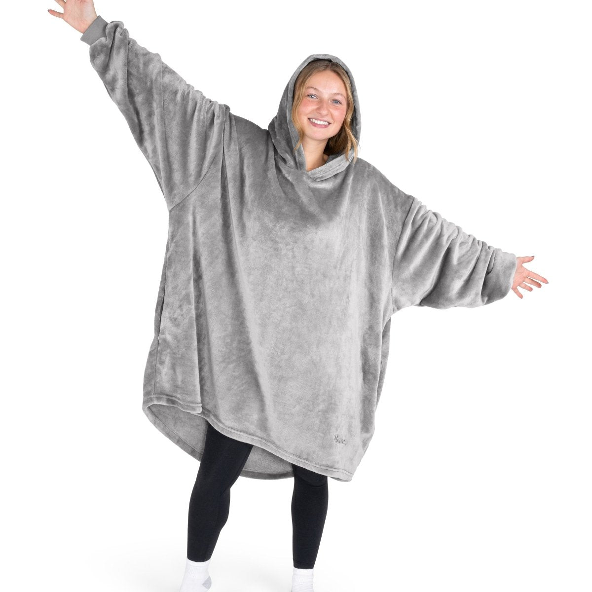 A woman wearing a hooded blanket made of microplush, showcasing comfort and warmth