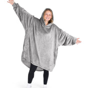 A woman wearing a hooded blanket made of microplush, showcasing comfort and warmth