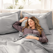 A woman is sleeping on a bed made with organic cotton sateen sheets