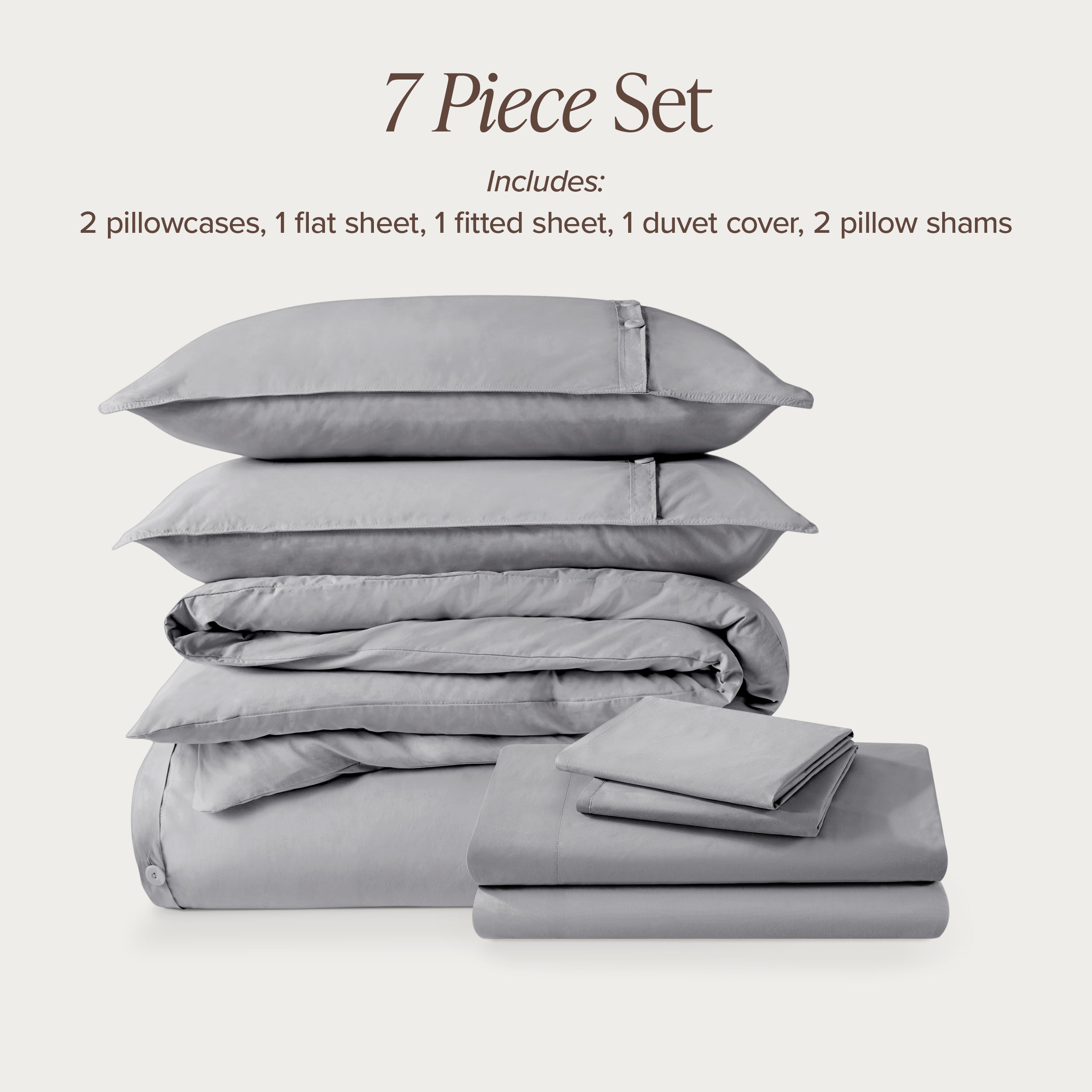 7-piece percale bedding set with pillowcases, flat sheet, fitted sheet, duvet cover, and pillow shams on a light background.