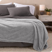 A double sided sherpa blanket on a bed
