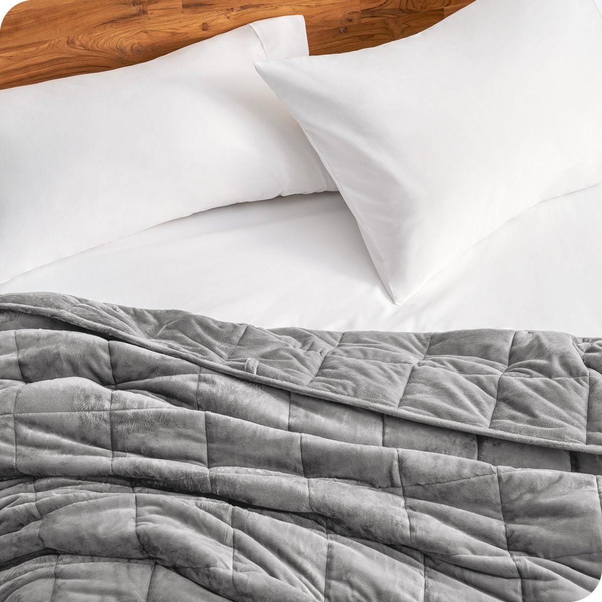 Close up of a weighted blanket on a bed next to pillows