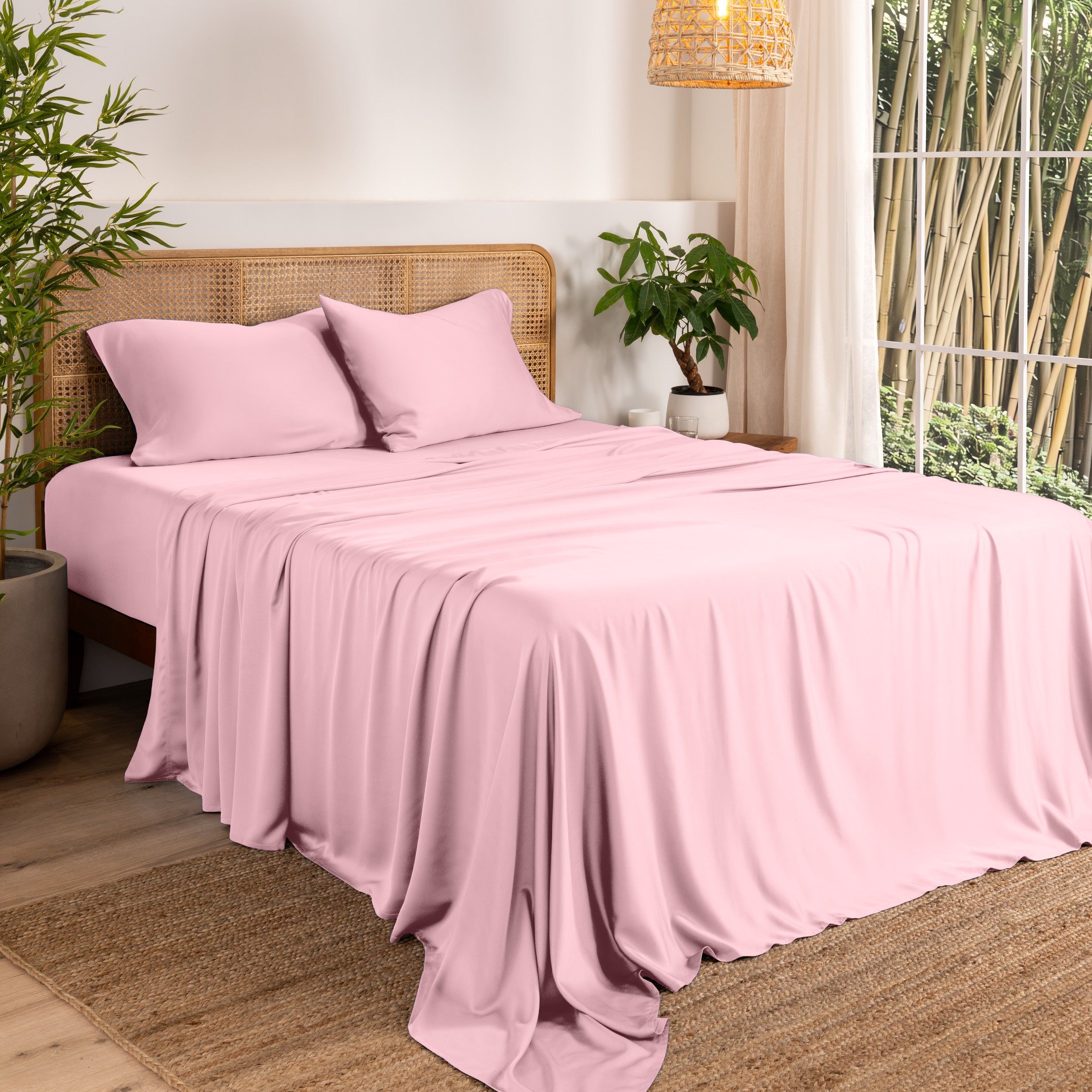 Bamboo sheets on a bed in a bedroom with plants and a lamp.