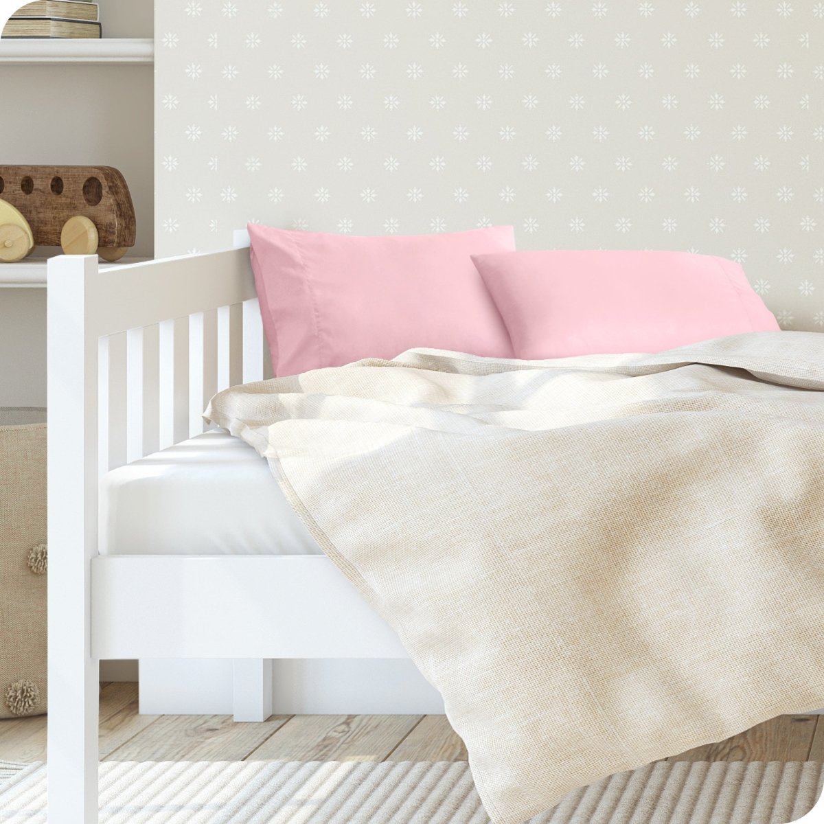 A toddler's bed with 2 microfiber pillowcases on pillows