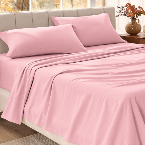 Bed sheets on a neatly made bed in a bright bedroom with large windows.
