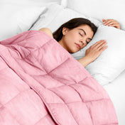 Woman sleeping peacefully under a weighted blanket with white pillows