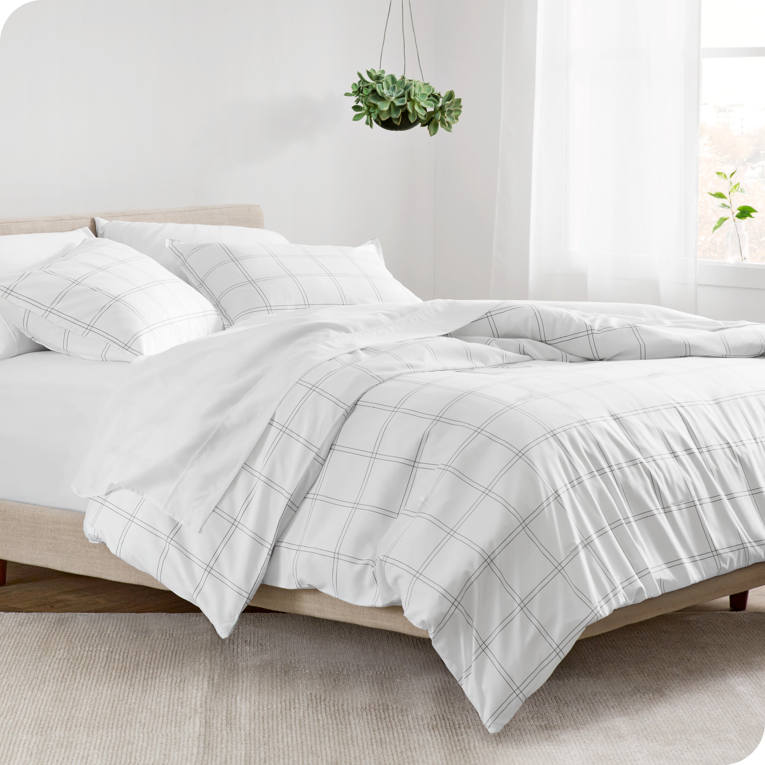 A side view of a printed comforter on a bed with a wooden frame and headboard