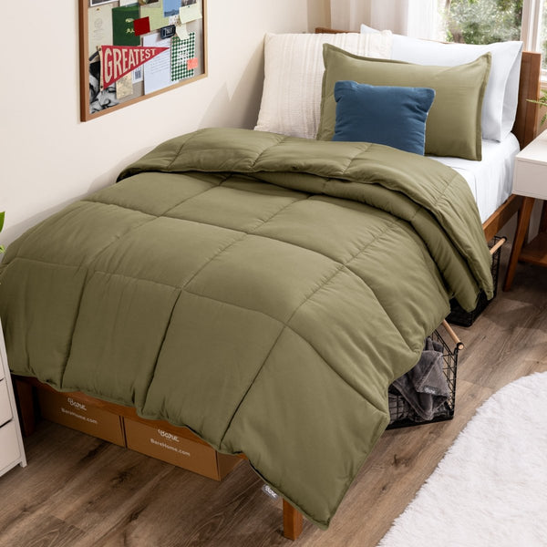 Bed with comforter and pillows in a dorm room
