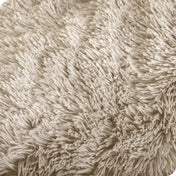 A shaggy faux fur blanket draped over the arm of a chair