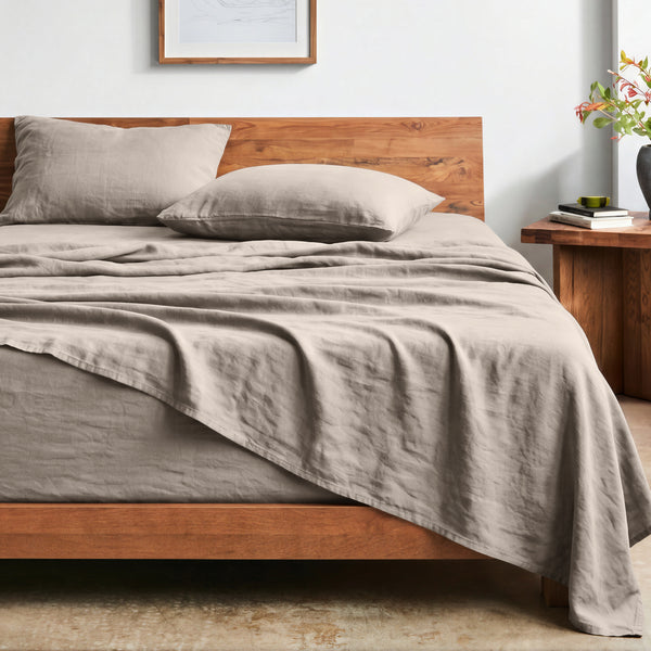 Bed with washed sheets and wooden headboard in a bedroom setting