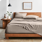 Modern bedroom with washed sheets draped over the end and the side of the bed