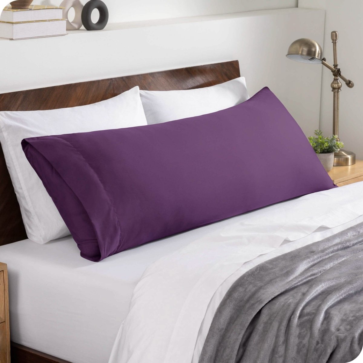 A body pillowcase on a pillow set against a headboard