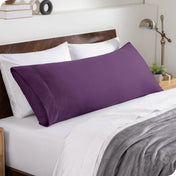 A body pillowcase on a pillow set against a headboard