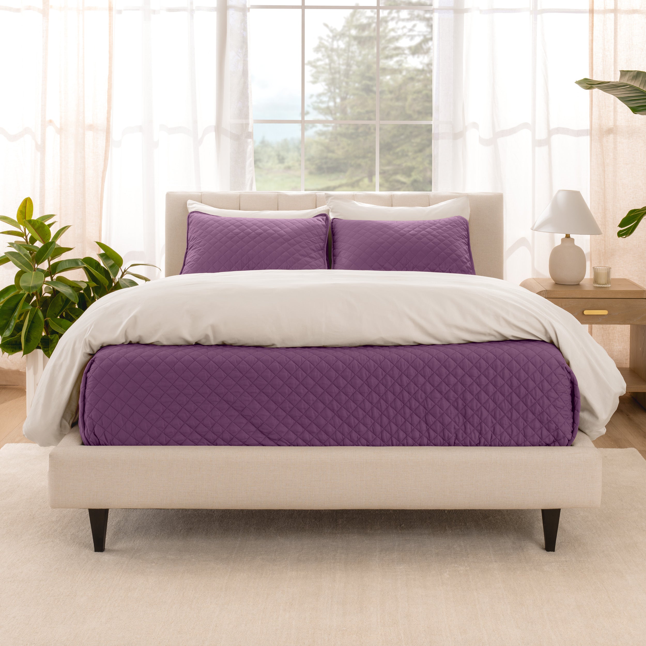 A bright bedroom with a coverlet set on the bed