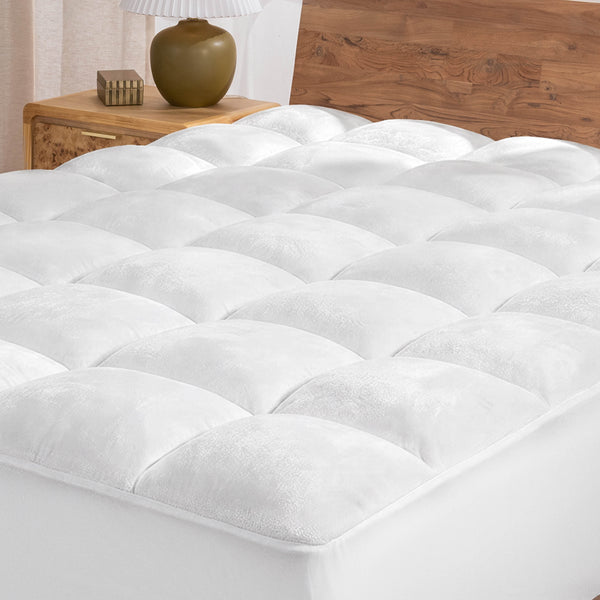 White mattress topper on a wooden bed with a neutral background