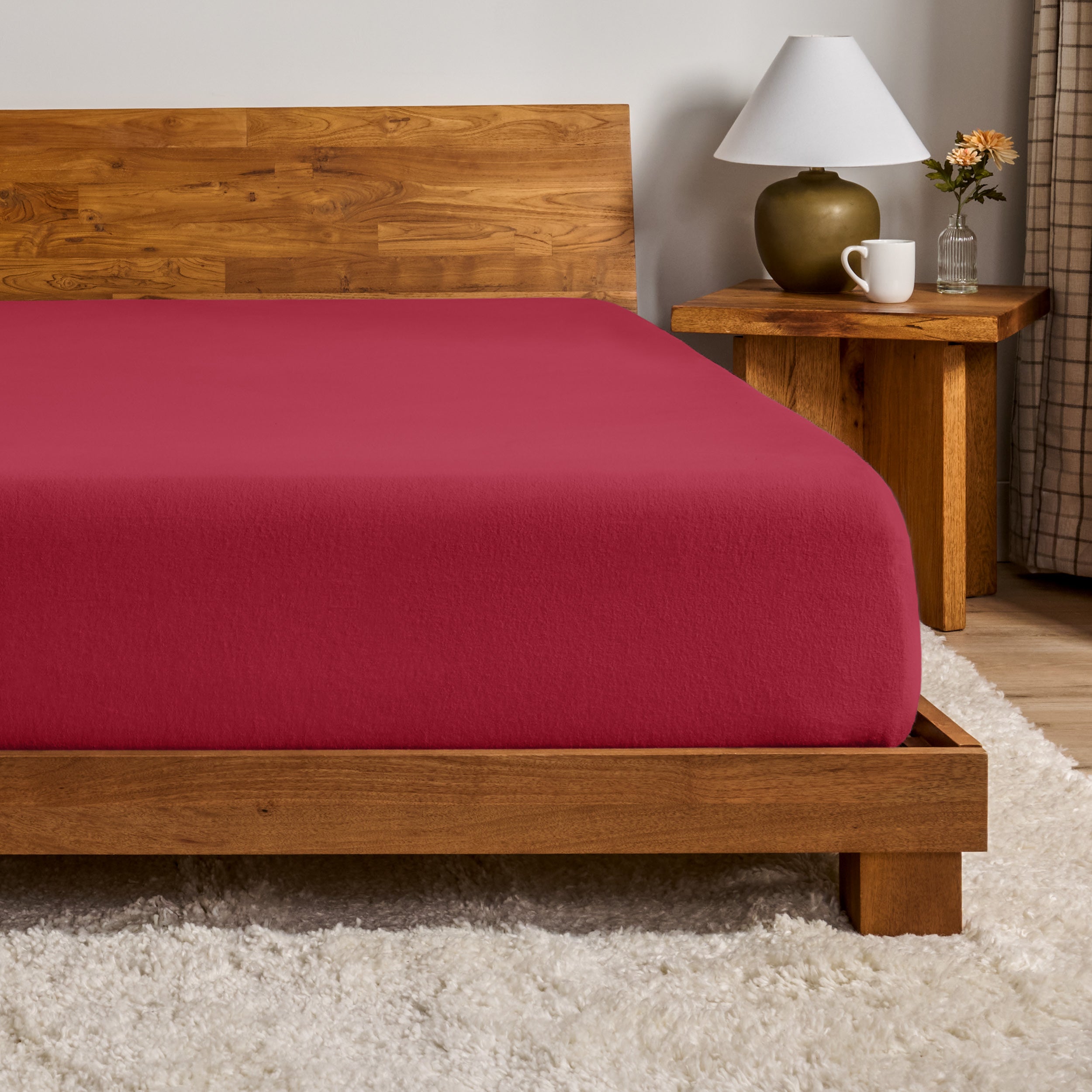A flannel fitted sheet on a mattress with a wooden bed frame