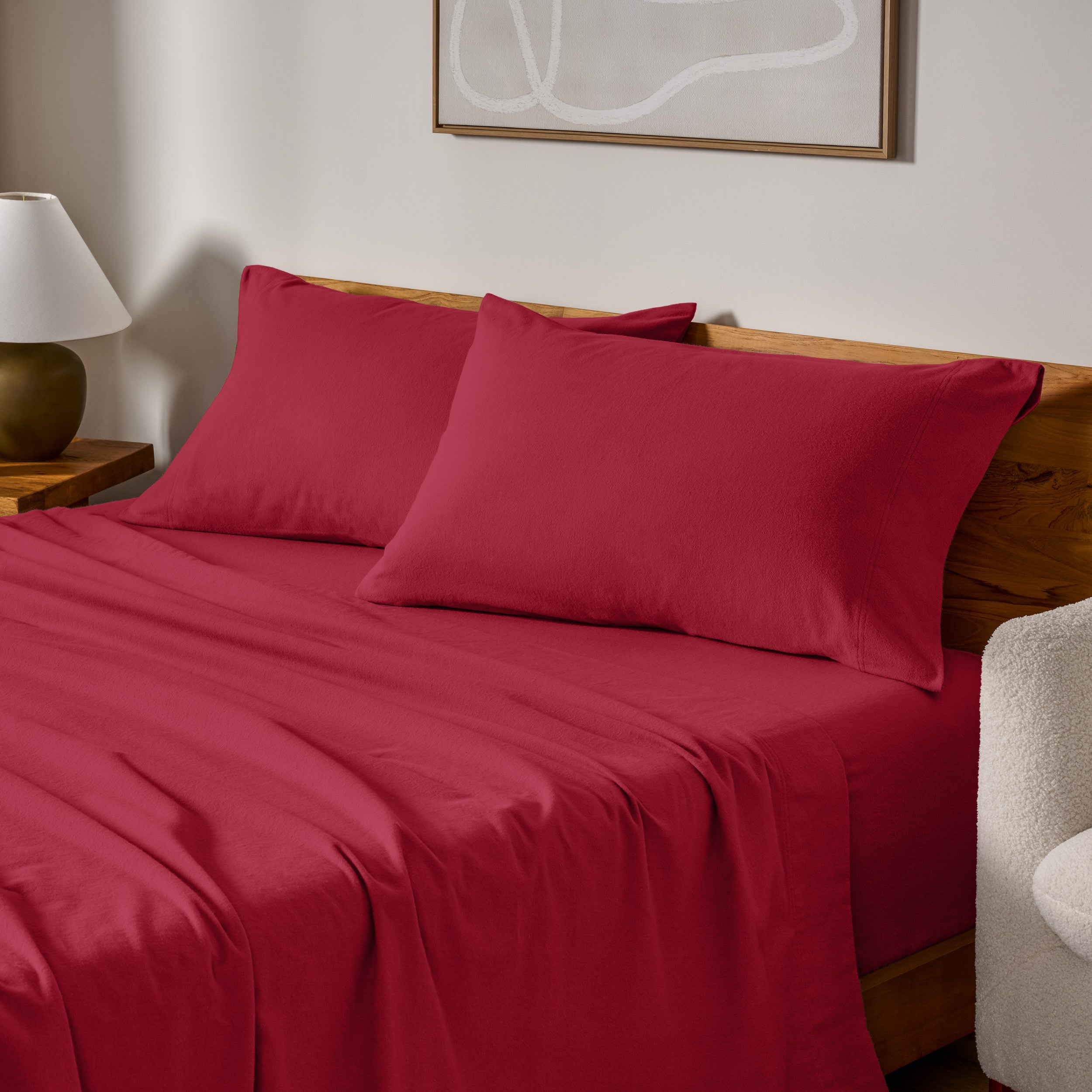 Cotton flannel sheets and pillows on a wooden bed in a bedroom setting.
