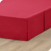 A box spring with a bed skirt on it
