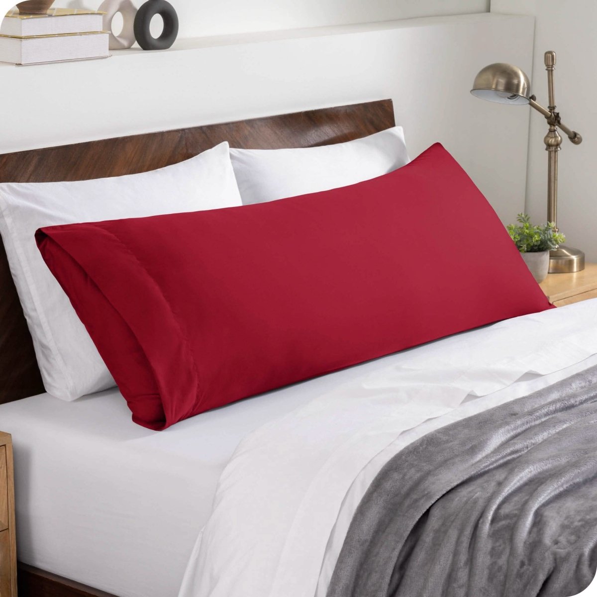 A body pillowcase on a pillow set against a headboard