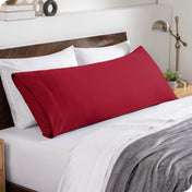 A body pillowcase on a pillow set against a headboard
