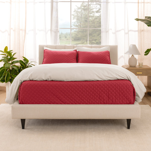 A bright bedroom with a coverlet set on the bed