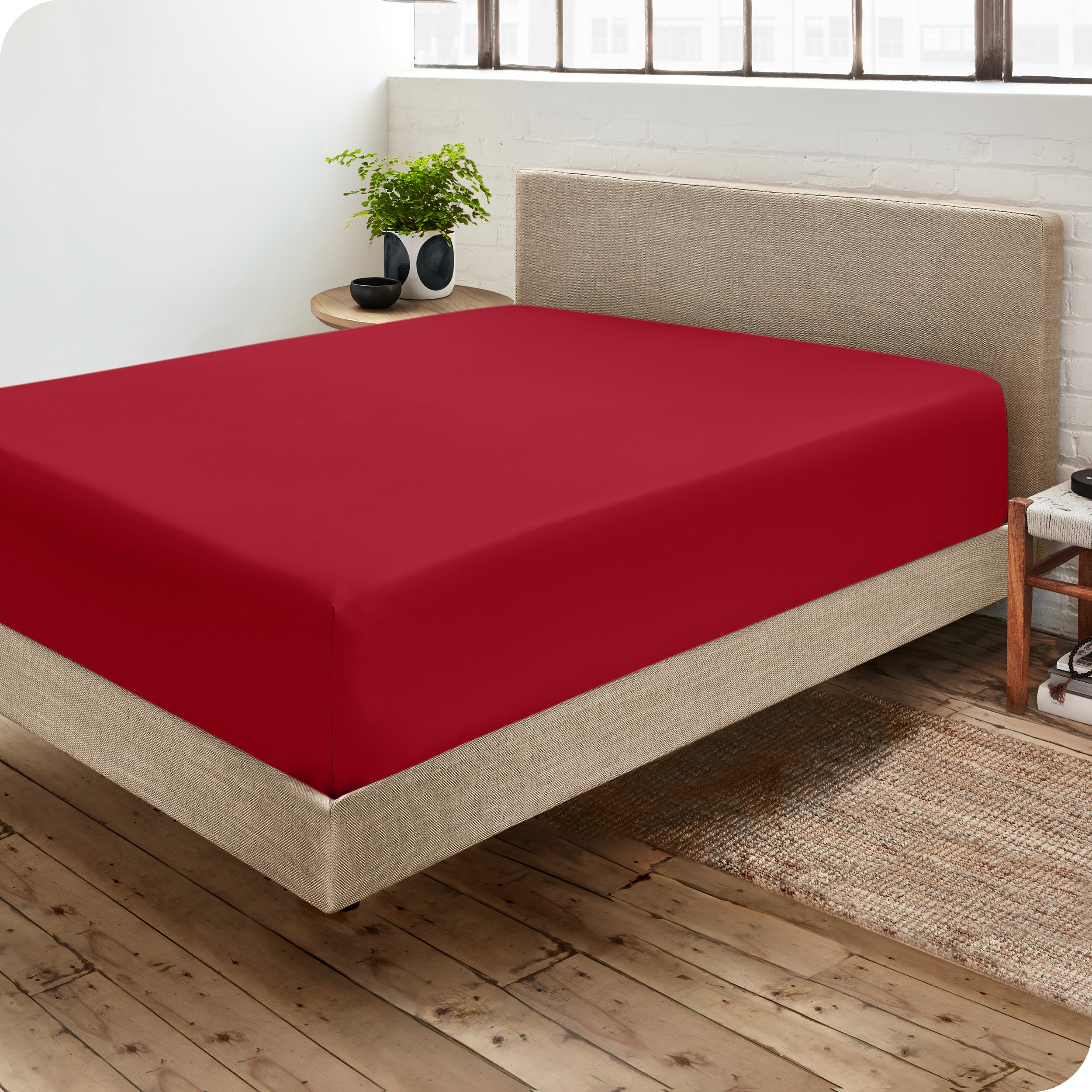 A side view of a bed made with a fitted sheet on it