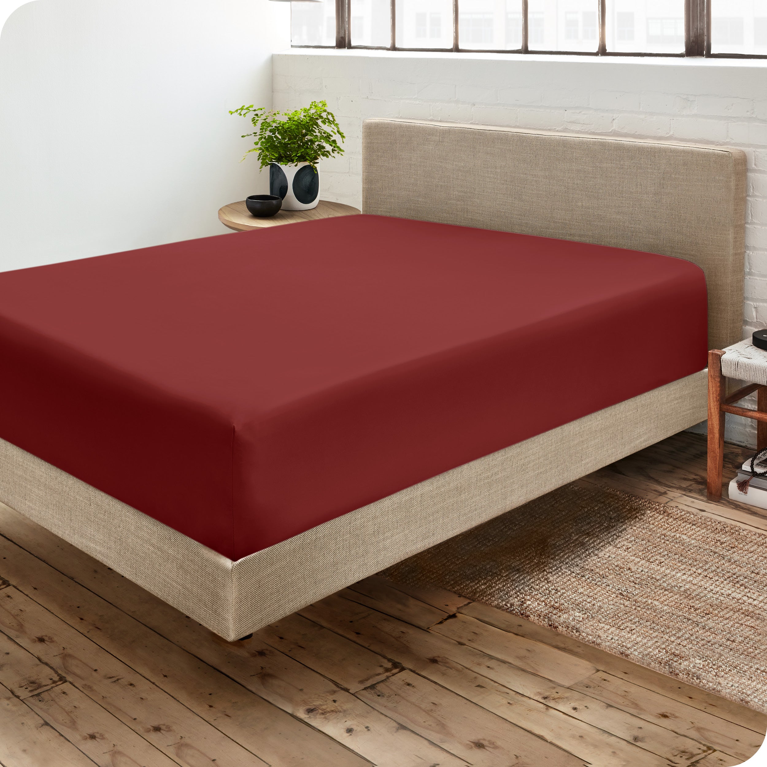 A side view of a bed made with a fitted sheet on it