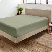 A side view of a bed made with a fitted sheet on it