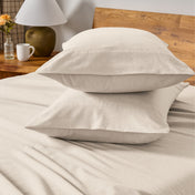 Flannel bedding set on a bed with a beige headboard and lamp.