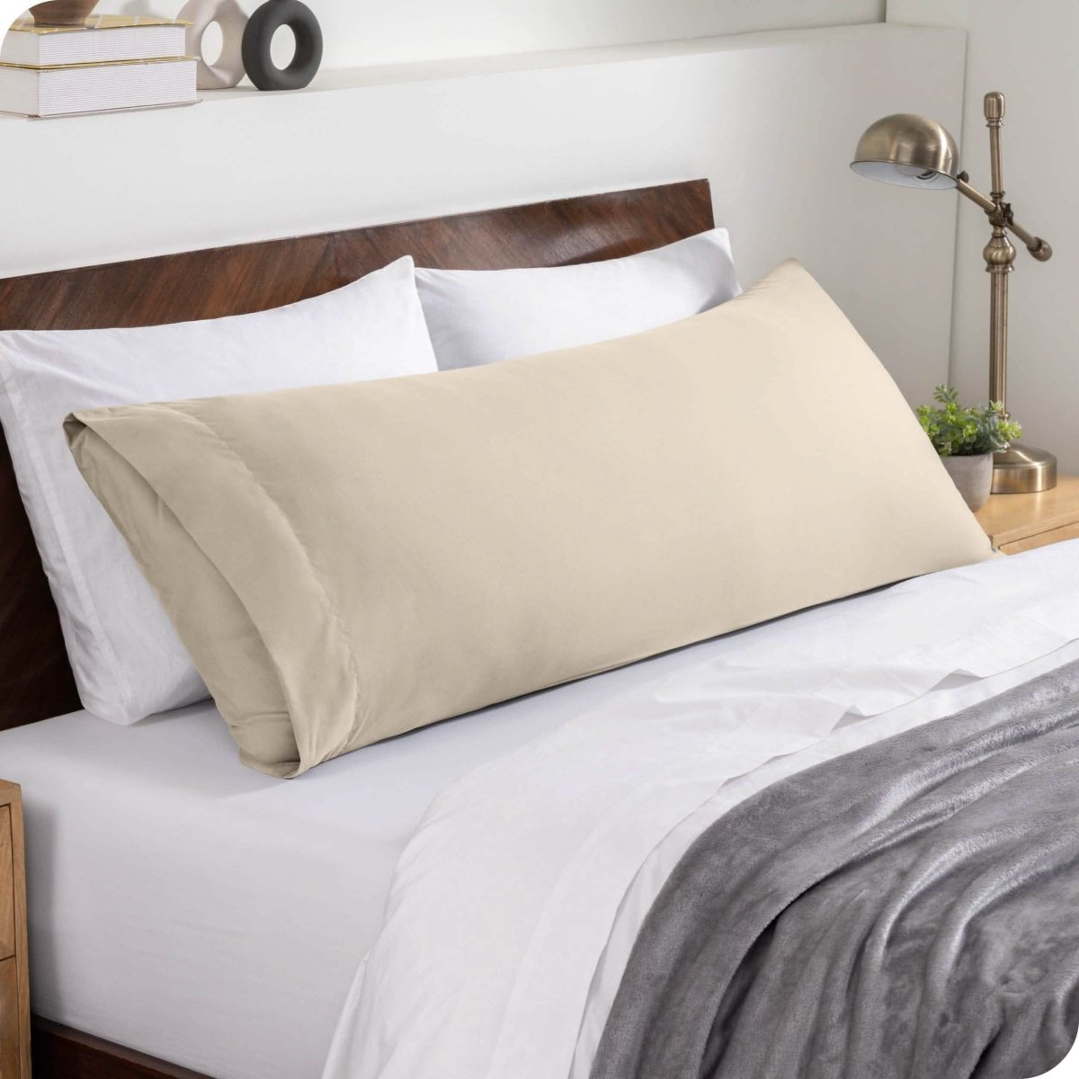 A body pillowcase on a pillow set against a headboard