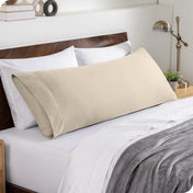 A body pillowcase on a pillow set against a headboard