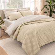 Bedroom showing coverlet set laying on the bed with the quilt folded over on itself