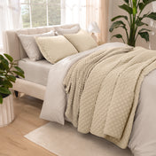 Side view of bed with coverlet set draped on a bed made with a duvet set