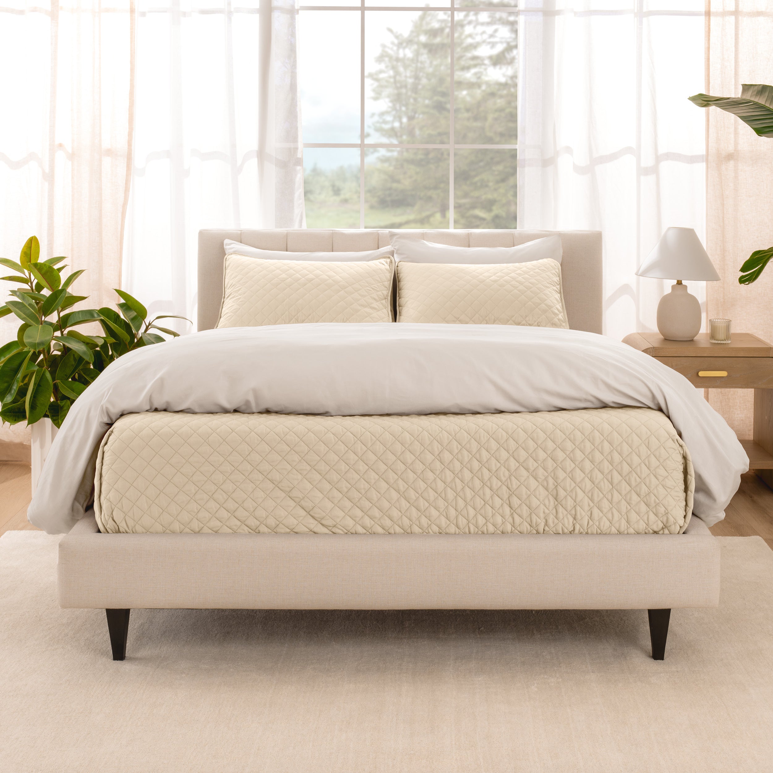 A bright bedroom with a coverlet set on the bed